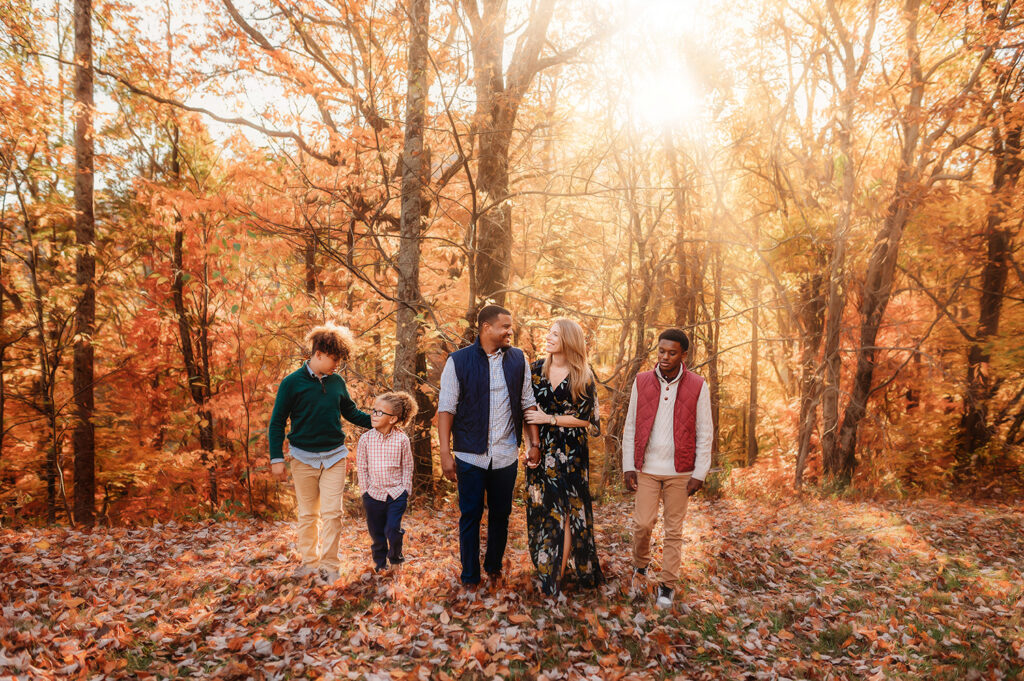Family walks through the fall foliage during Fall Family Portraits on the Blue Ridge Parkway in Asheville, NC.