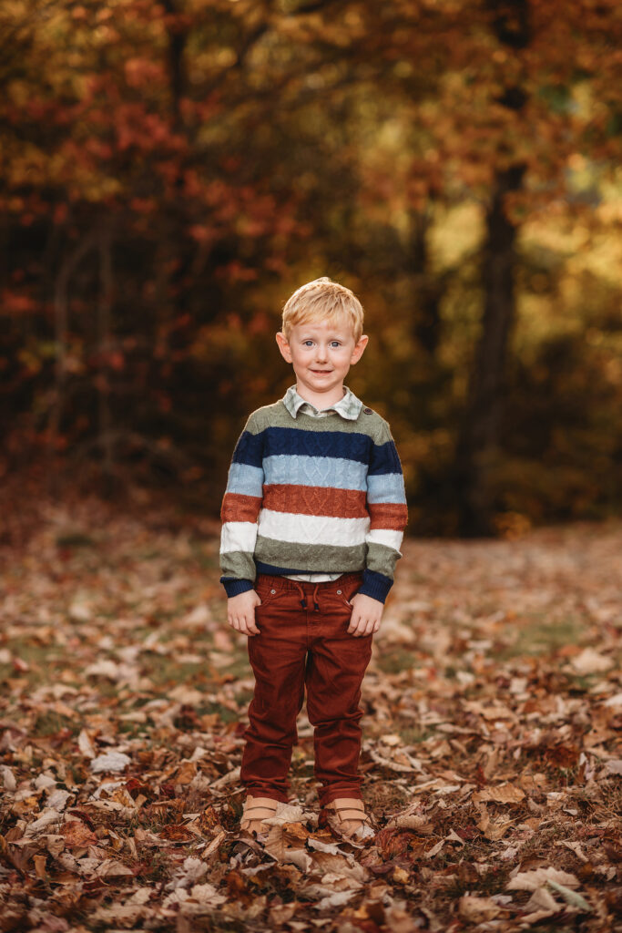 Little boy smiles at the camera during Fall Family Photos on the Blue Ridge Parkway in Asheville, NC.