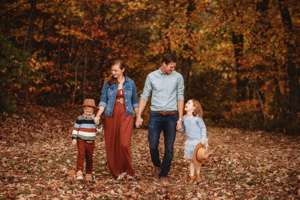 Family walks through fall foliage during Family Photos on the Blue Ridge Parkway in Asheville, NC.
