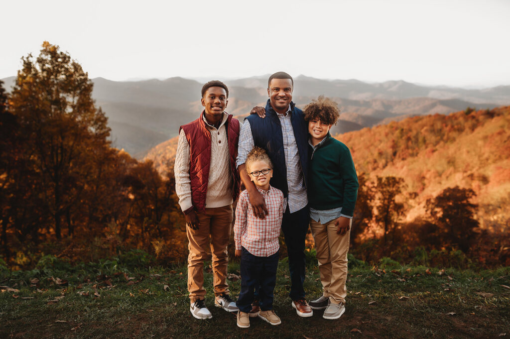 Family poses for Fall Family Portraits on a Mountain top during Family Portraits on the Blue Ridge Parkway in Asheville, NC.