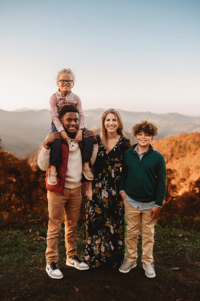 Family poses for Fall Family Portraits on a Mountain top during Family Portraits on the Blue Ridge Parkway in Asheville, NC.