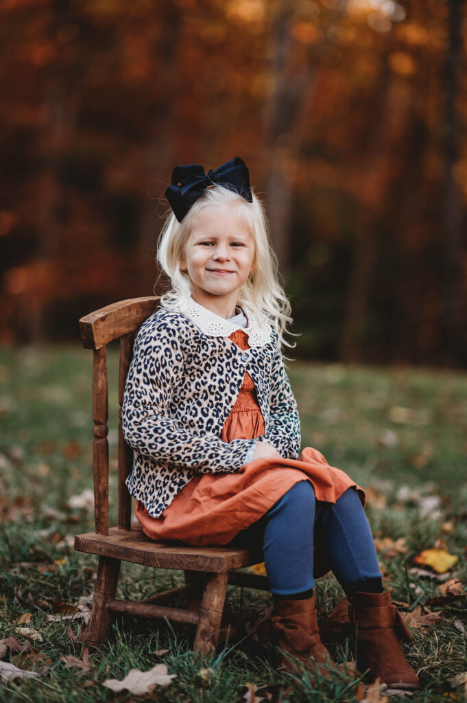 Young girl smiles at the camera during Fall Family Portraits Session at Biltmore Estate in Asheville, NC.