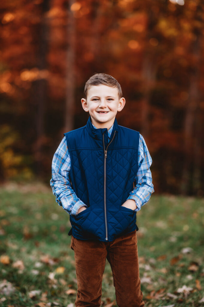 Young boy smiles at the camera during Fall Family Portraits Session at Biltmore Estate in Asheville, NC.