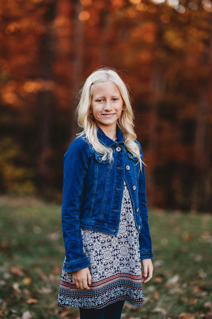 Young girl smiles at the camera during Fall Family Portraits Session at Biltmore Estate in Asheville, NC.