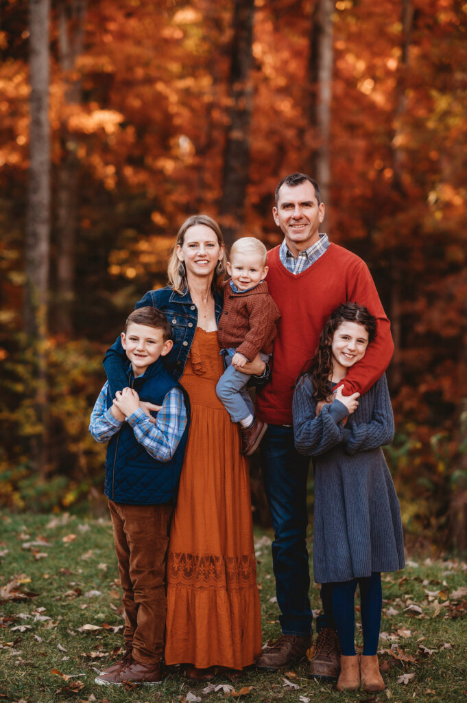 Family poses together for Fall Family Portraits at Biltmore Estate in Asheville, NC after learning about the Best Places to See Fall Color in Asheville.