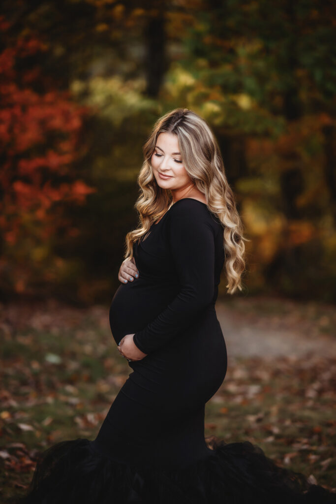 Expectant mother poses for Maternity Portraits in the fall, on the Blue Ridge Parkway with Asheville Portrait Company after Planning a Babymoon in Asheville, NC.