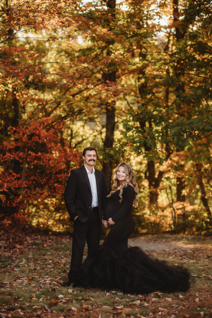 Expectant parents pose for Maternity Portraits in the fall, on the Blue Ridge Parkway with Asheville Portrait Company after Planning a Babymoon in Asheville, NC.
