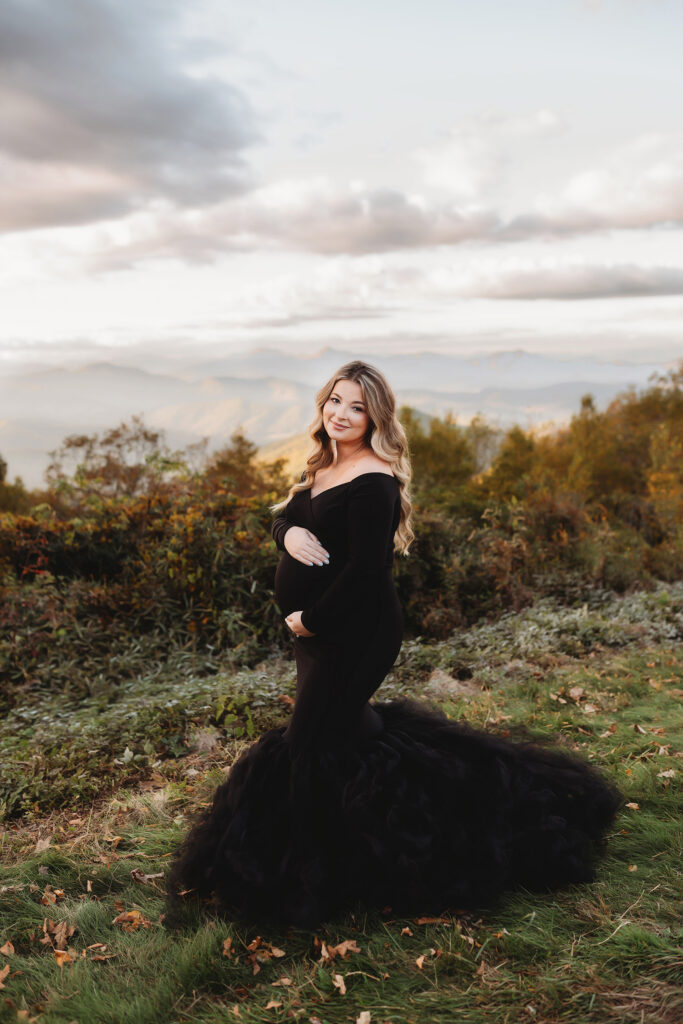 Expectant mother poses for Maternity Portraits in the fall, on the Blue Ridge Parkway with Asheville Portrait Company after Planning a Babymoon in Asheville, NC.