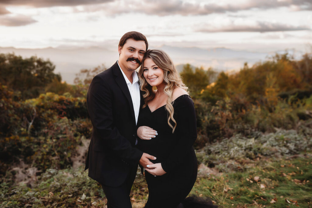Expectant parents pose for Maternity Portraits in the fall, on the Blue Ridge Parkway with Asheville Portrait Company after Planning a Babymoon in Asheville, NC.