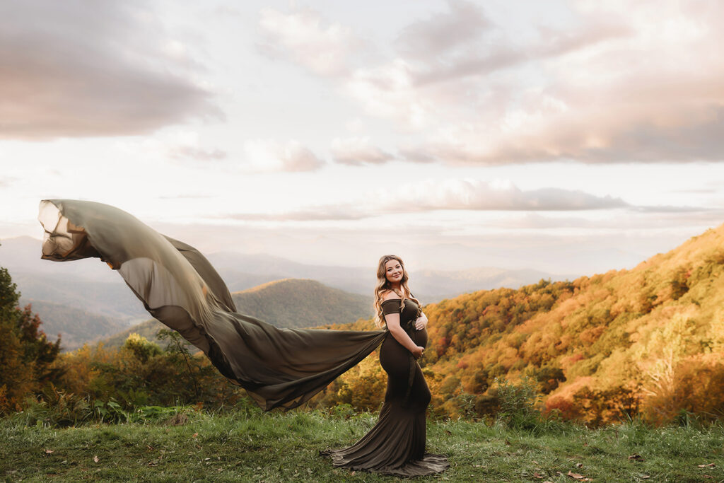 Expectant mother poses for Maternity Portraits in the fall, on the Blue Ridge Parkway with Asheville Portrait Company after Planning a Babymoon in Asheville, NC.
