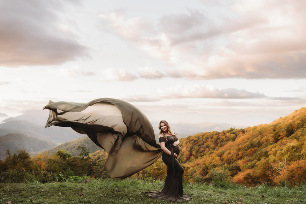 Expectant mother poses for Maternity Portraits in the fall, on the Blue Ridge Parkway with Asheville Portrait Company after Planning a Babymoon in Asheville, NC.