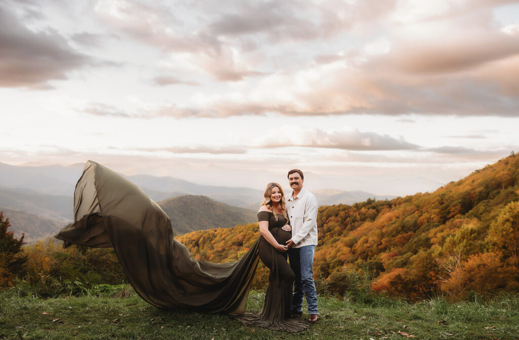 Expectant parents pose for Maternity Portraits in the fall, on the Blue Ridge Parkway with Asheville Portrait Company after Planning a Babymoon in Asheville, NC.