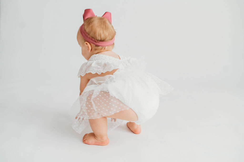 Candid Photos of a toddler during a simple, all white studio photoshoot in Asheville, NC portrait studio.