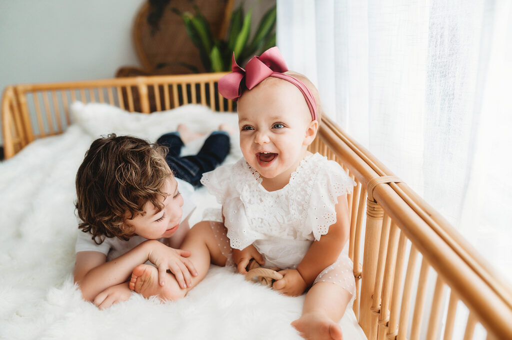 Siblings pose for a simple, all white studio photoshoot in Asheville, NC portrait studio.