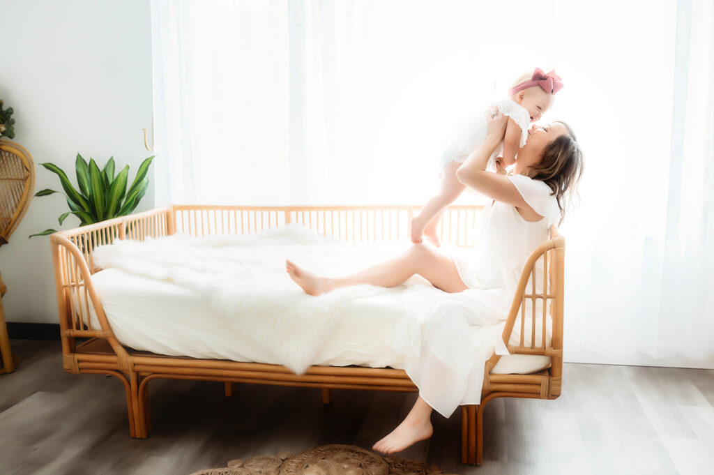 Mother poses with her daughter for a simple, all white studio photoshoot in Asheville, NC portrait studio.
