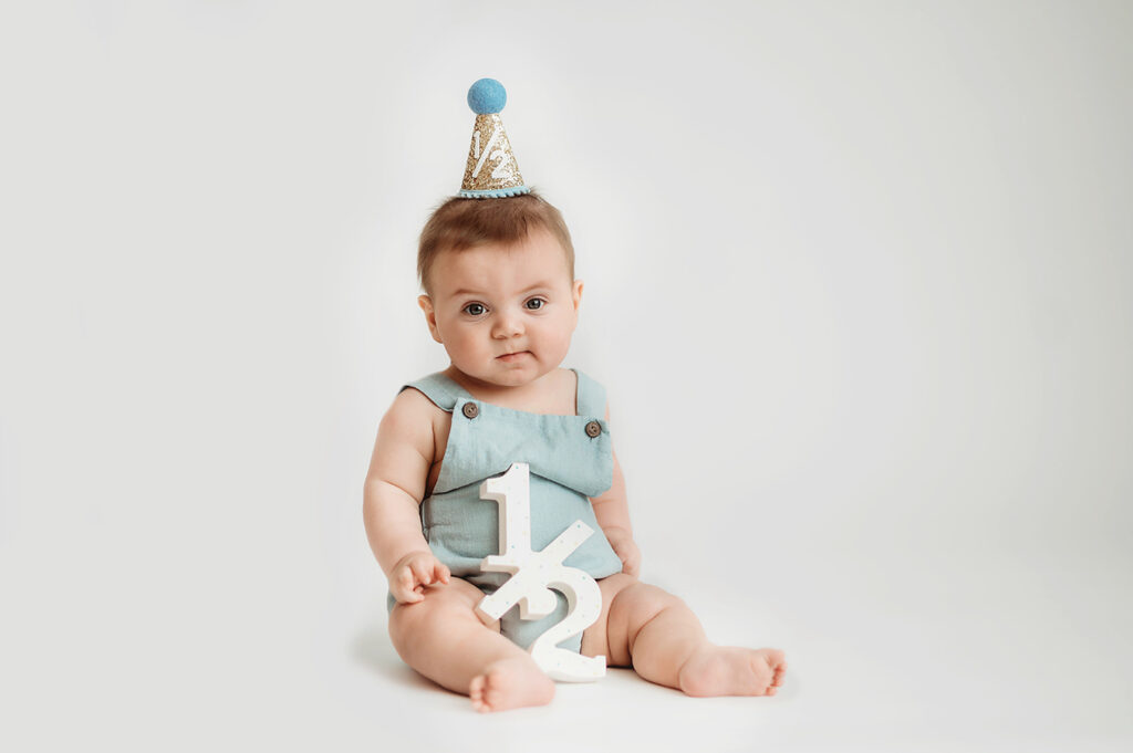 Baby poses for Birthday Cake Smash Portrait Session in Asheville, NC Photo Studio.
