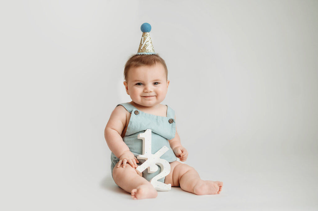 Baby poses for Birthday Cake Smash Portrait Session in Asheville, NC Photo Studio.