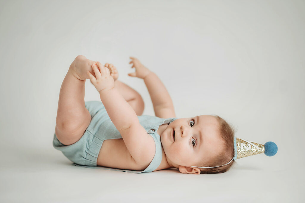 Baby poses for Birthday Cake Smash Portrait Session in Asheville, NC Photo Studio.