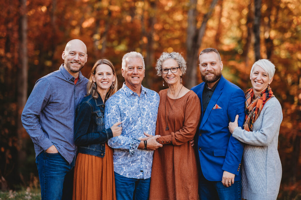Family poses together for Fall Family Portraits at Biltmore Estate in Asheville, NC after learning about the Best Places to See Fall Color in Asheville.