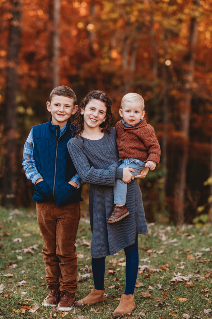 Siblings smile at the camera during Fall Family Portraits Session in Asheville, NC.