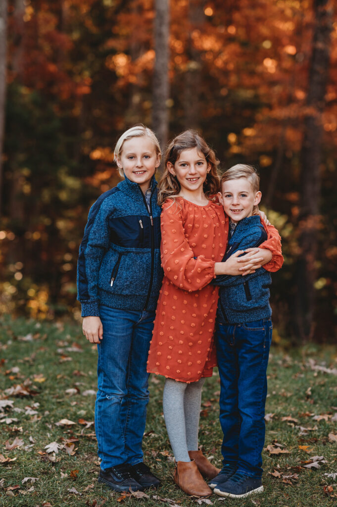 Siblings smile at the camera during Fall Family Portraits in Asheville, NC.