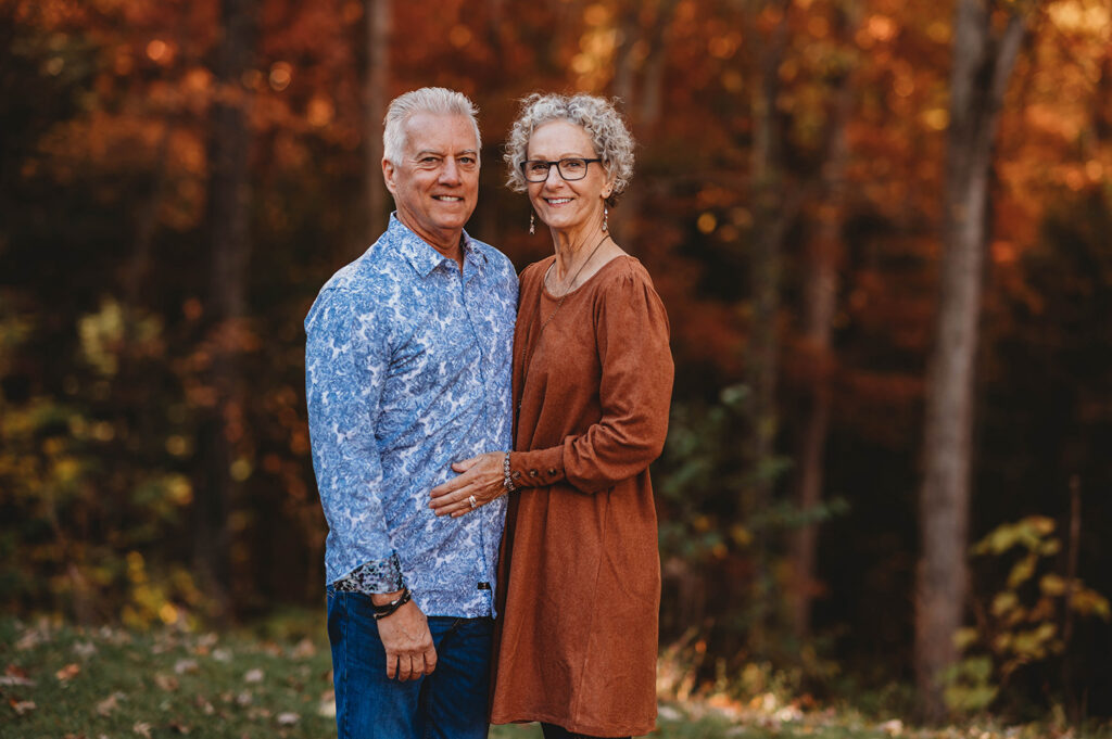 Couple poses together for Fall Family Portraits at Biltmore Estate in Asheville, NC after learning about the Best Places to See Fall Color in Asheville.