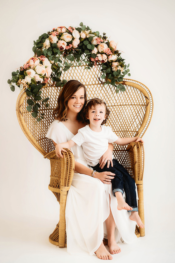 Mother poses with her son for a simple, all white studio photoshoot in Asheville, NC portrait studio.