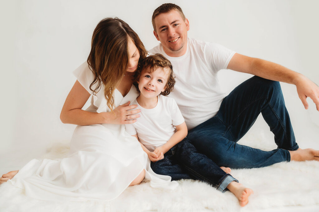 Family poses for simple, all white studio photoshoot in Asheville, NC photography studio.