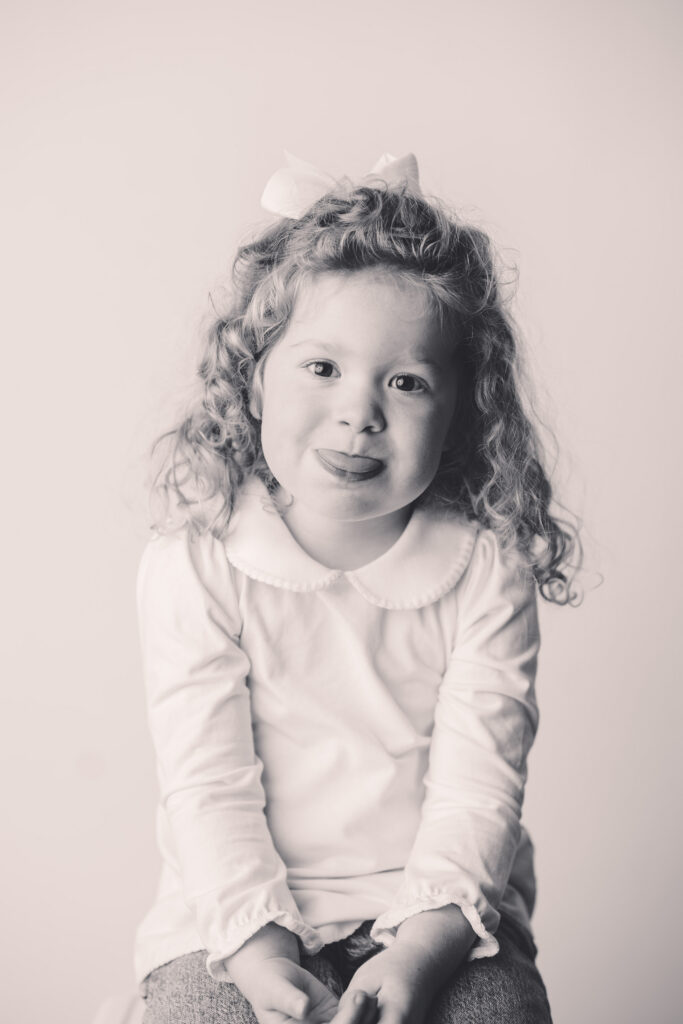 Little girl makes silly faces at the camera during Asheville Personality Portrait Pop-Up.
