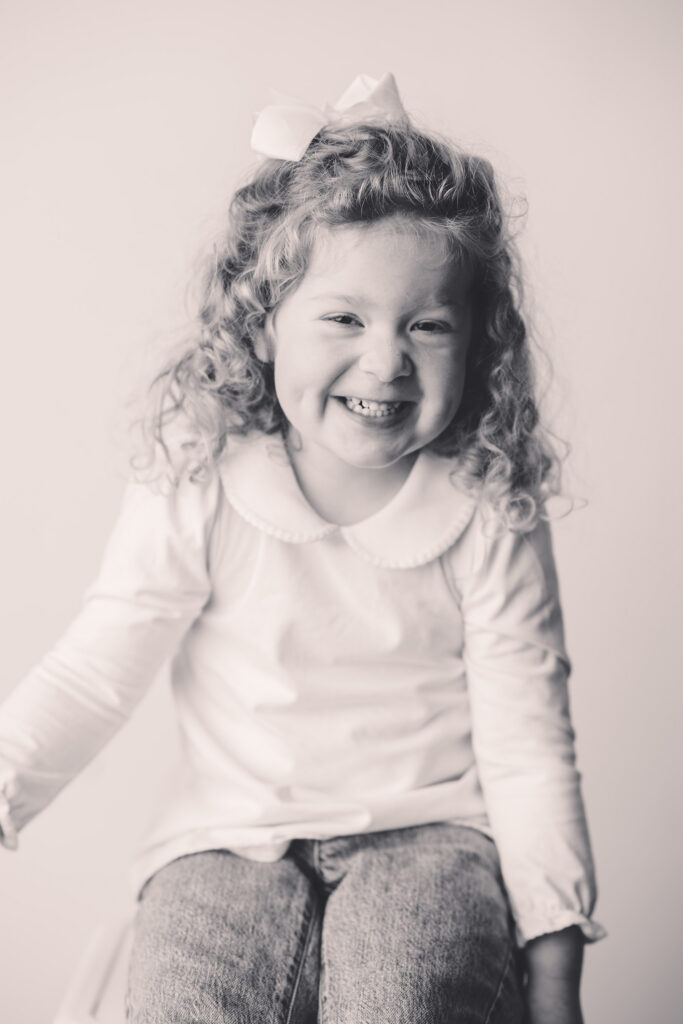 Little girl makes silly faces at the camera during Asheville Personality Portrait Pop-Up.