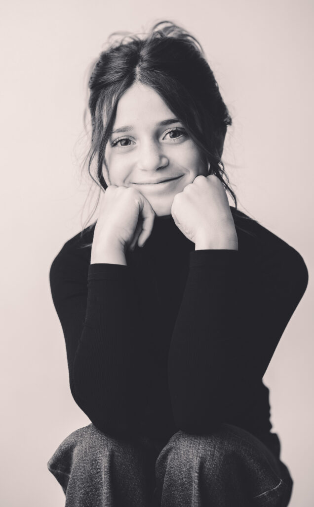 Young girl smiles at the camera during Asheville Personality Portrait Pop-Up.