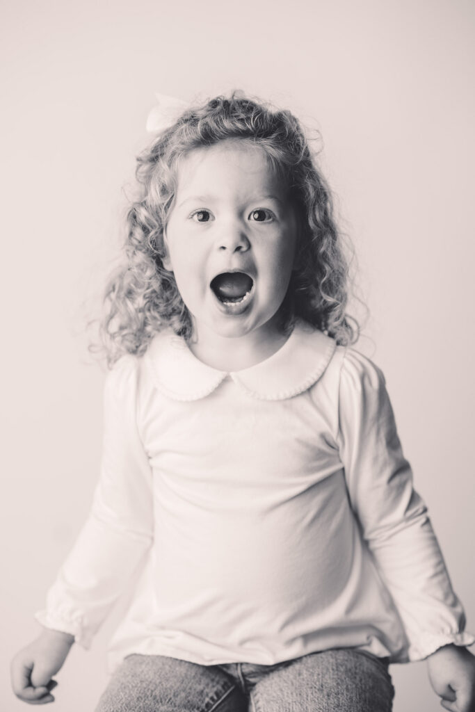 Little girl makes silly faces at the camera during Asheville Personality Portrait Pop-Up.