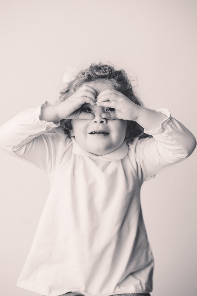 Little girl makes silly faces at the camera during Asheville Personality Portrait Pop-Up.