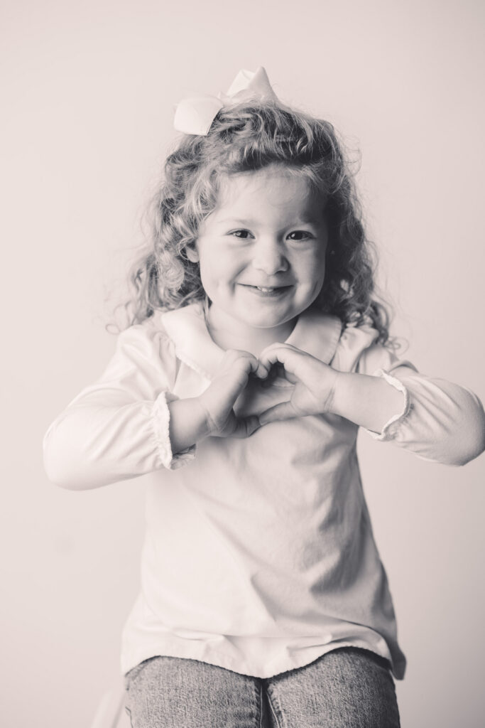 Little girl makes silly faces at the camera during Asheville Personality Portrait Pop-Up.
