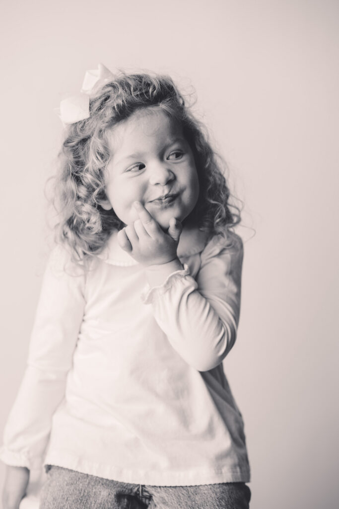 Little girl makes silly faces at the camera during Asheville Personality Portrait Pop-Up.