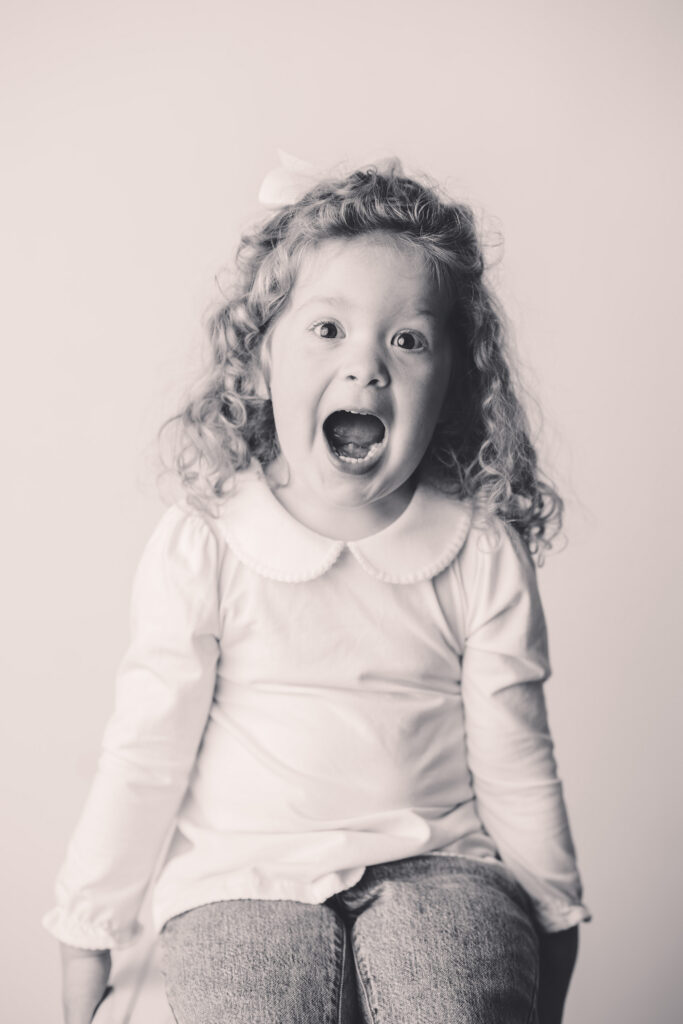 Little girl makes silly faces at the camera during Asheville Personality Portrait Pop-Up.