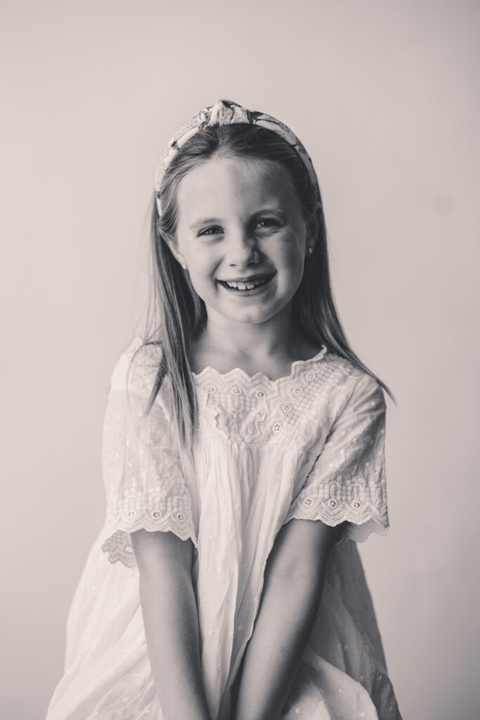 Little girl smiles at the camera during the Asheville Personality Portrait Pop Up