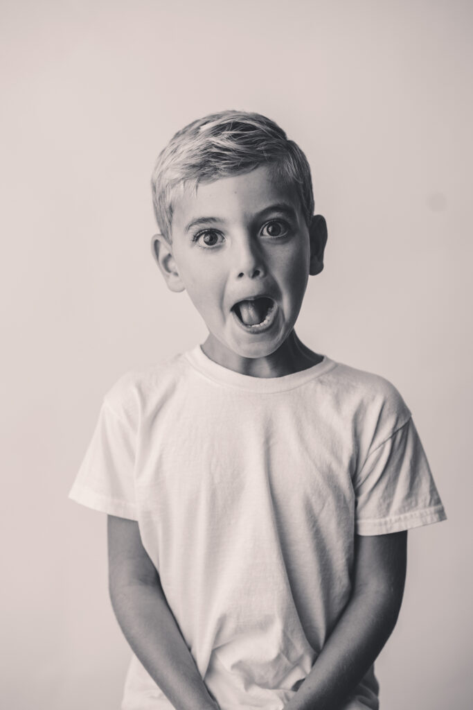 Child makes silly face at the camera during Personality Portrait Session in Asheville, NC.