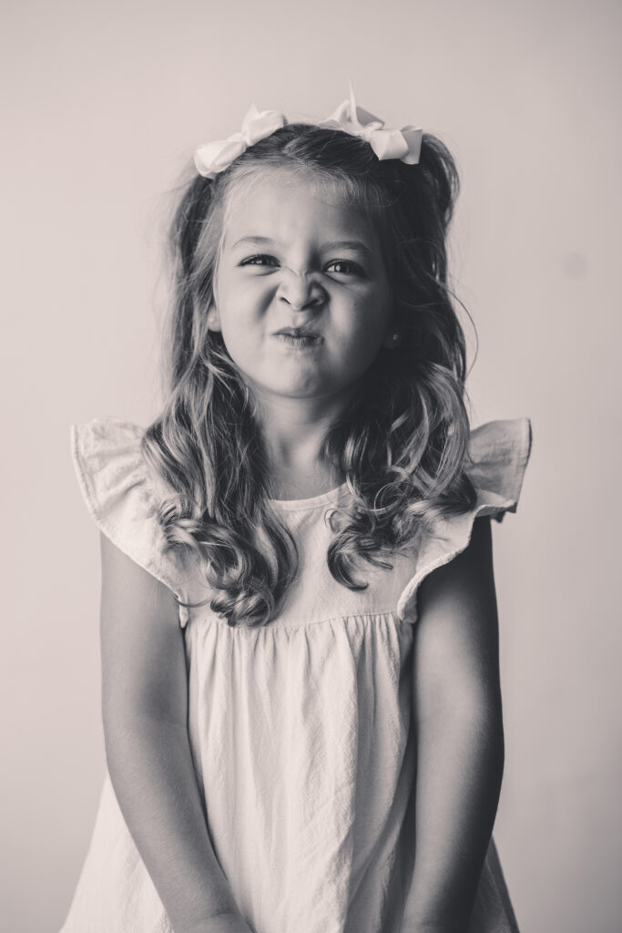 Child makes silly face at the camera during Personality Portrait Session in Asheville, NC.