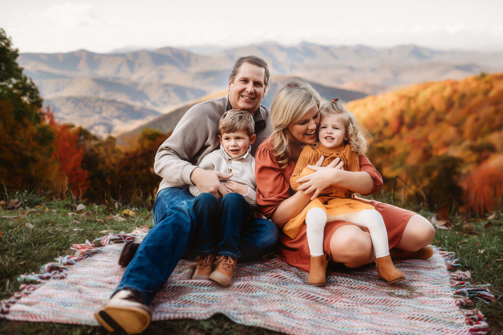 Parents tickle their children during Family Photos on the Blue Ridge Parkway outside of Asheville, NC in the fall. 