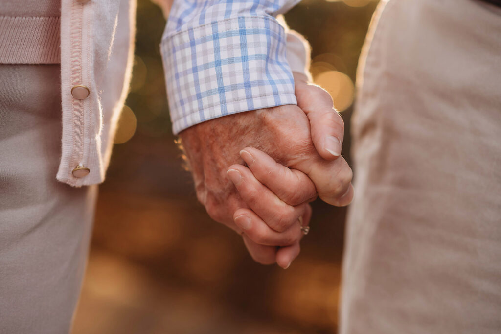 Grandparents hold hands during 
