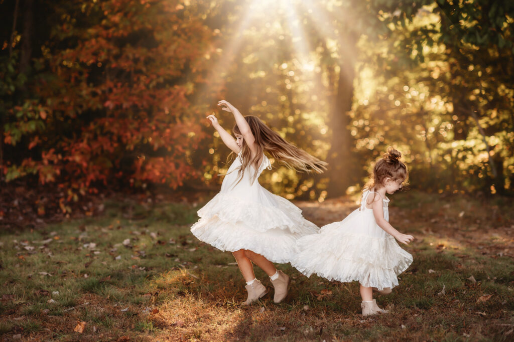 Little girls dance in the sunlight during their Family Portrait Session on the Blue Ridge Parkway in Asheville. 