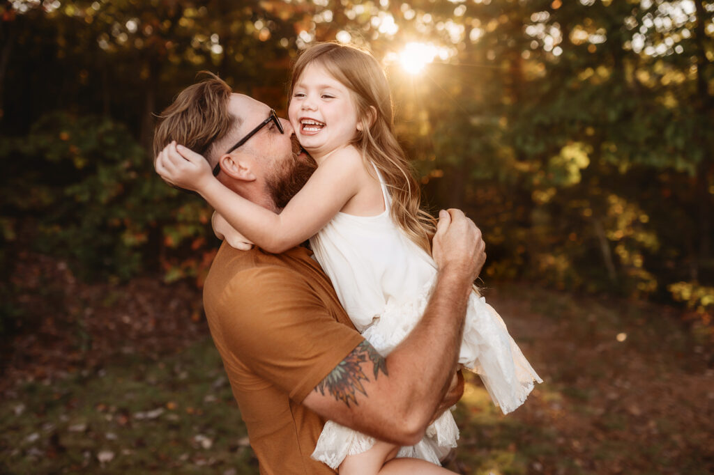 Father kisses his daughter during Family Pictures on the Blue Ridge Parkway near Asheville, NC.
