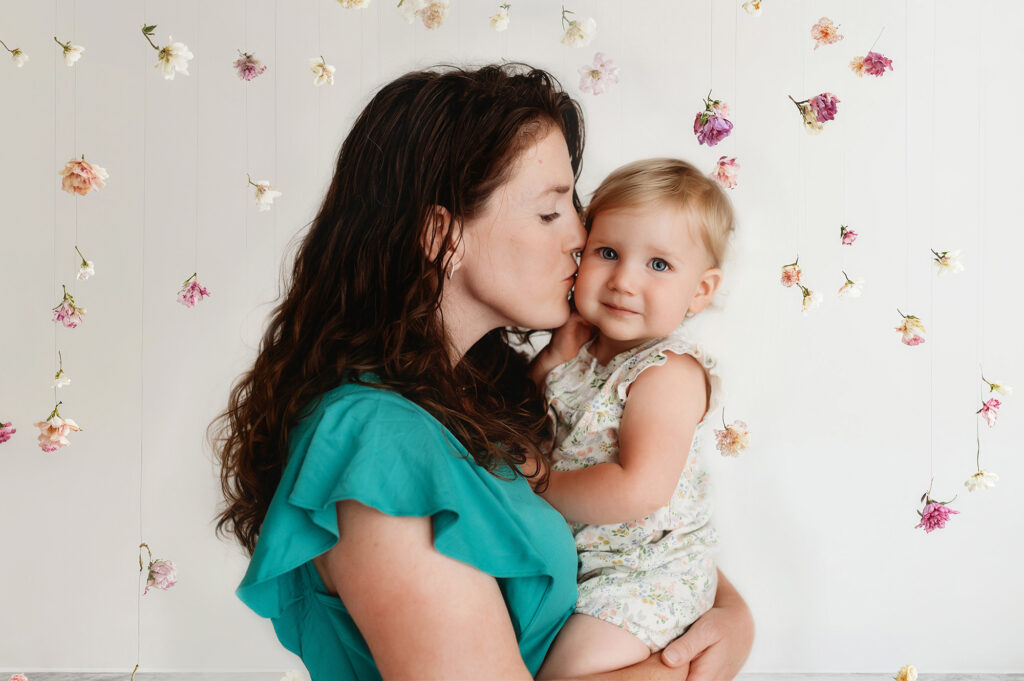 Mother kisses her baby during Mommy & Me Mini Sessions in Asheville. 