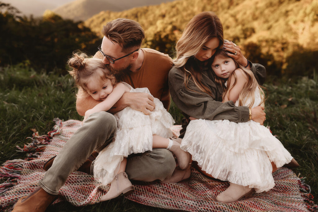 Mother and Father snuggle with their children during Family Portraits on the Blue Ridge Parkway in Asheville, NC.
