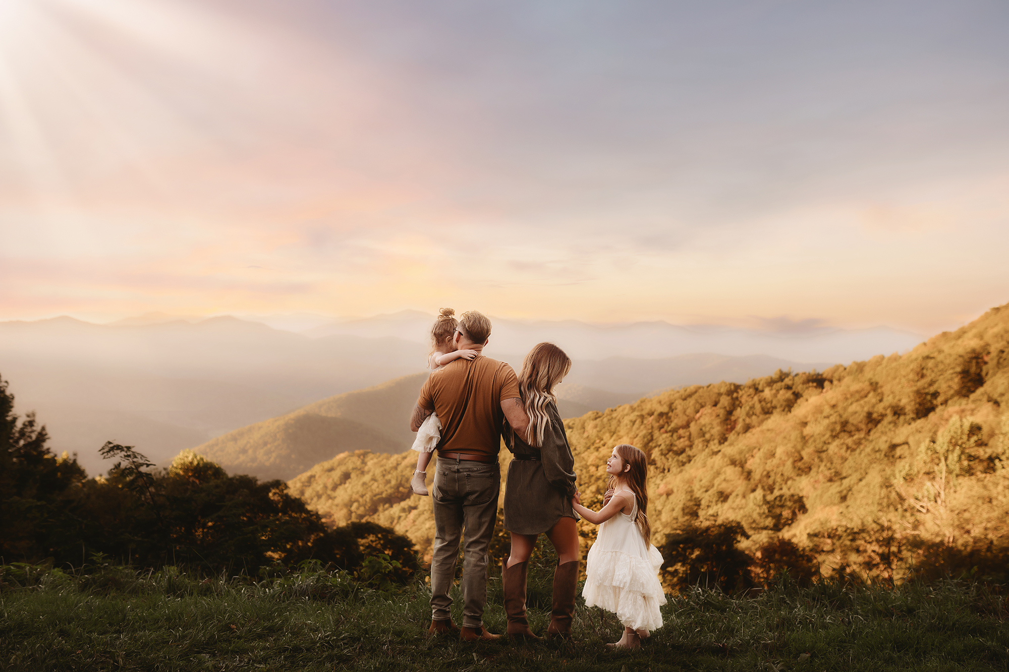 Family takes in the view from the Blue Ridge Parkway in Asheville during Fall Mini Sessions in Asheville, NC.
