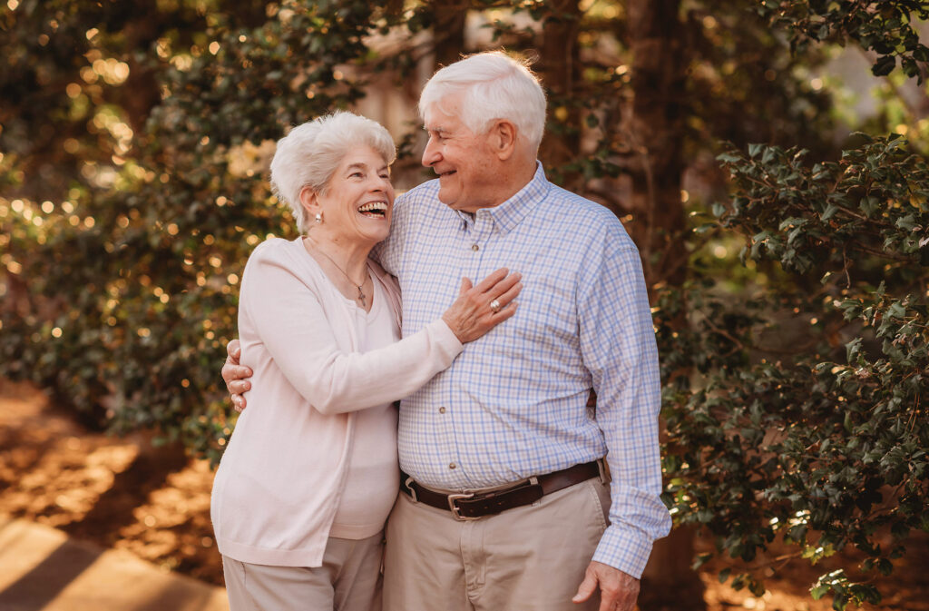 Grandparents laugh with each other during Family Photoshoot at the NC Arboretum in Asheville, NC. 