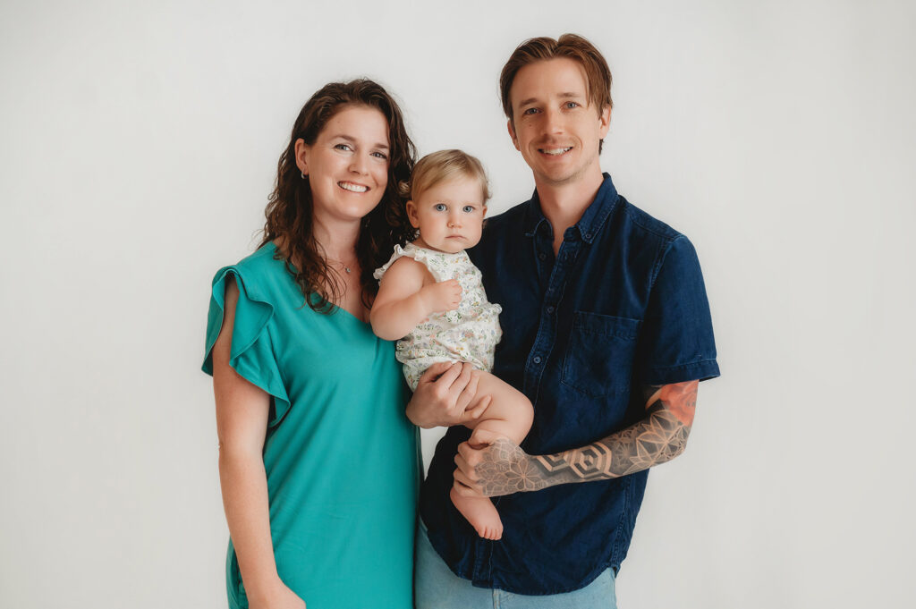 Parents embrace their baby during a Family Photoshoot in Asheville Portrait Studio.
