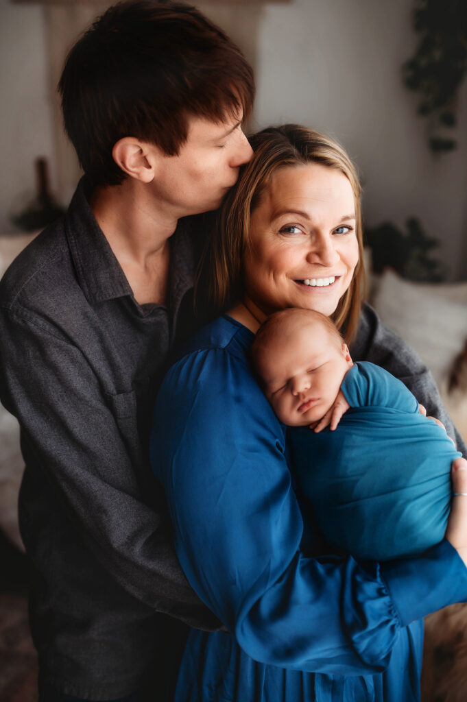 New parents embrace their infant during Newborn Portraits in Asheville, NC. 