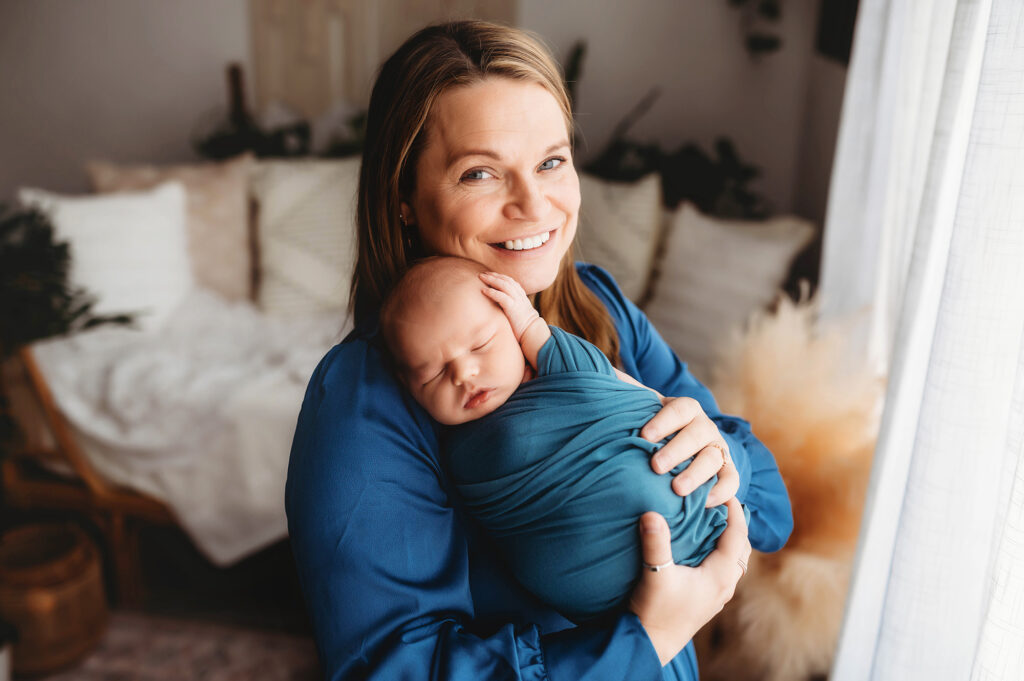 New mother embraces her infant during Newborn Photoshoot in Asheville while also receiving Breastfeeding Support in Asheville. 